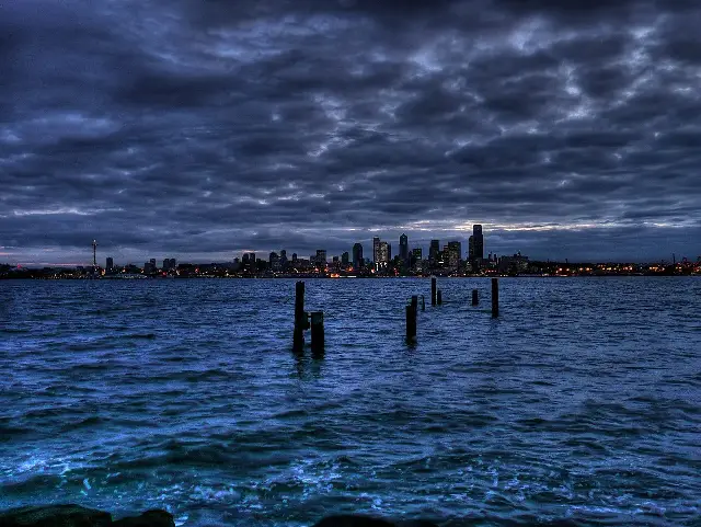 Illustrative: the Seattle skyline at dusk seen across the water from Alki Beach, near where the Denny Party landed in 1851.