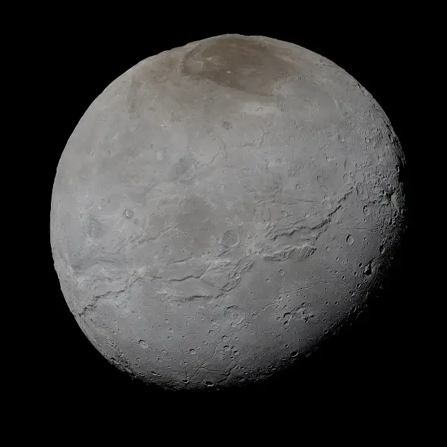 Pluto's moon Charon in enhanced true color, a gray cratered sphere with a dark reddish region across its north pole.