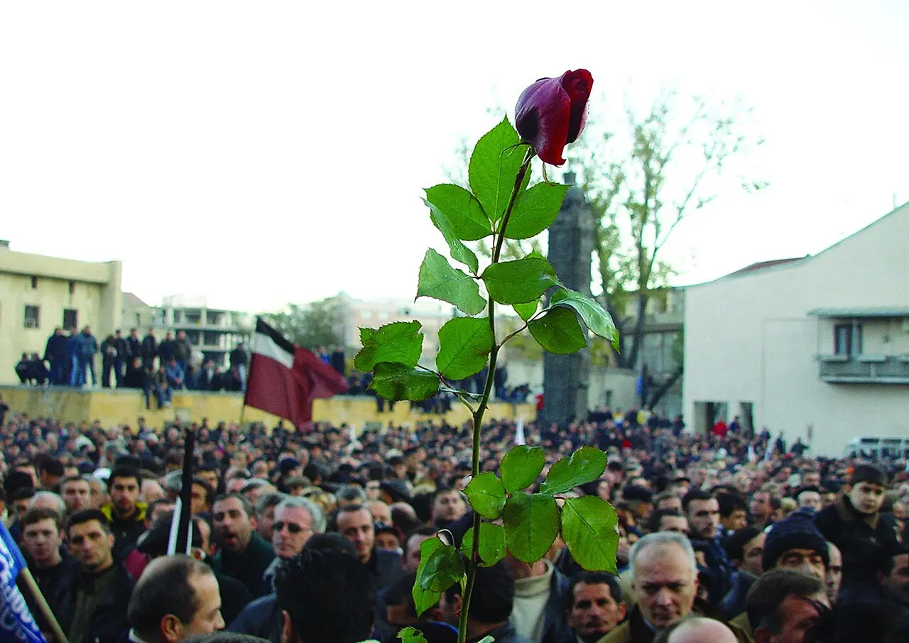 A red rose held aloft above a crowd of demonstrators in Tbilisi during Georgia's 2003 Rose Revolution.