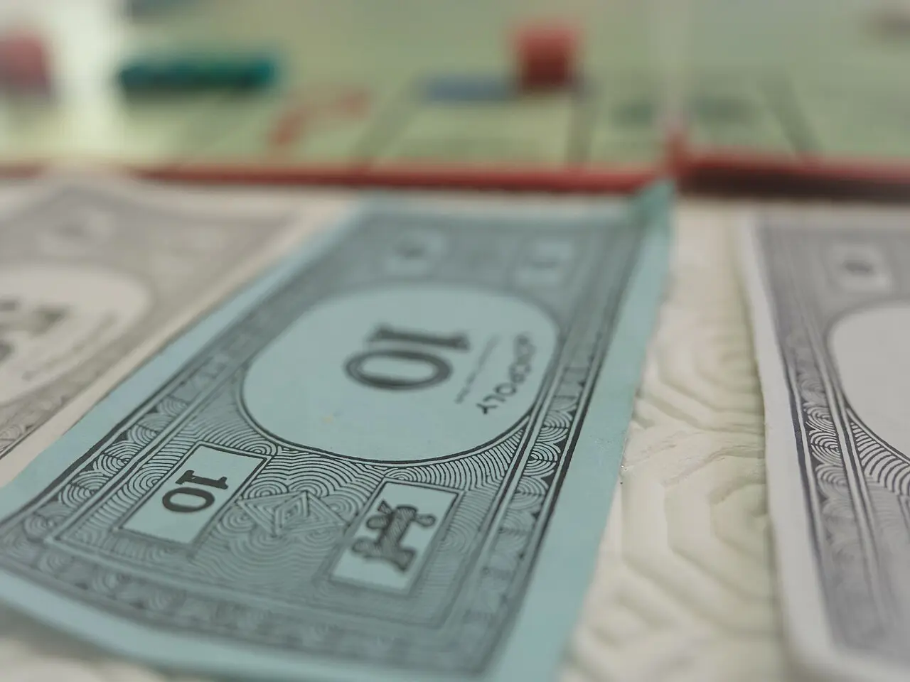 Illustrative: a modern Monopoly game in progress, with play money, tokens, and houses on the board.