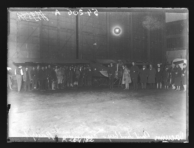 1927 press photograph of the crowd around Lindbergh's Spirit of St. Louis inside a hangar at Le Bourget aerodrome, France, the night of his solo transatlantic flight.
