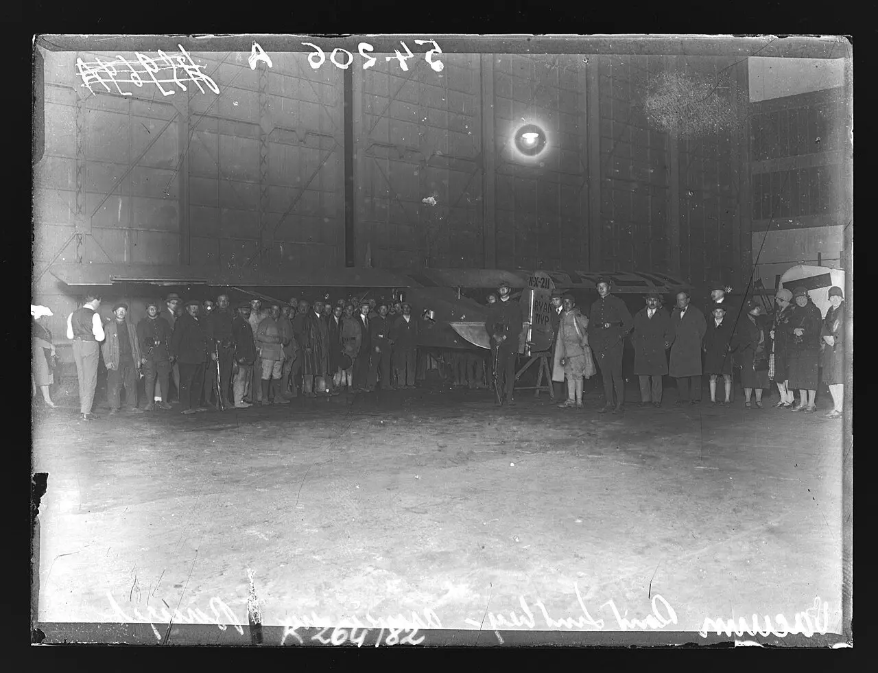 1927 press photograph of the crowd around Lindbergh's Spirit of St. Louis inside a hangar at Le Bourget aerodrome, France, the night of his solo transatlantic flight.