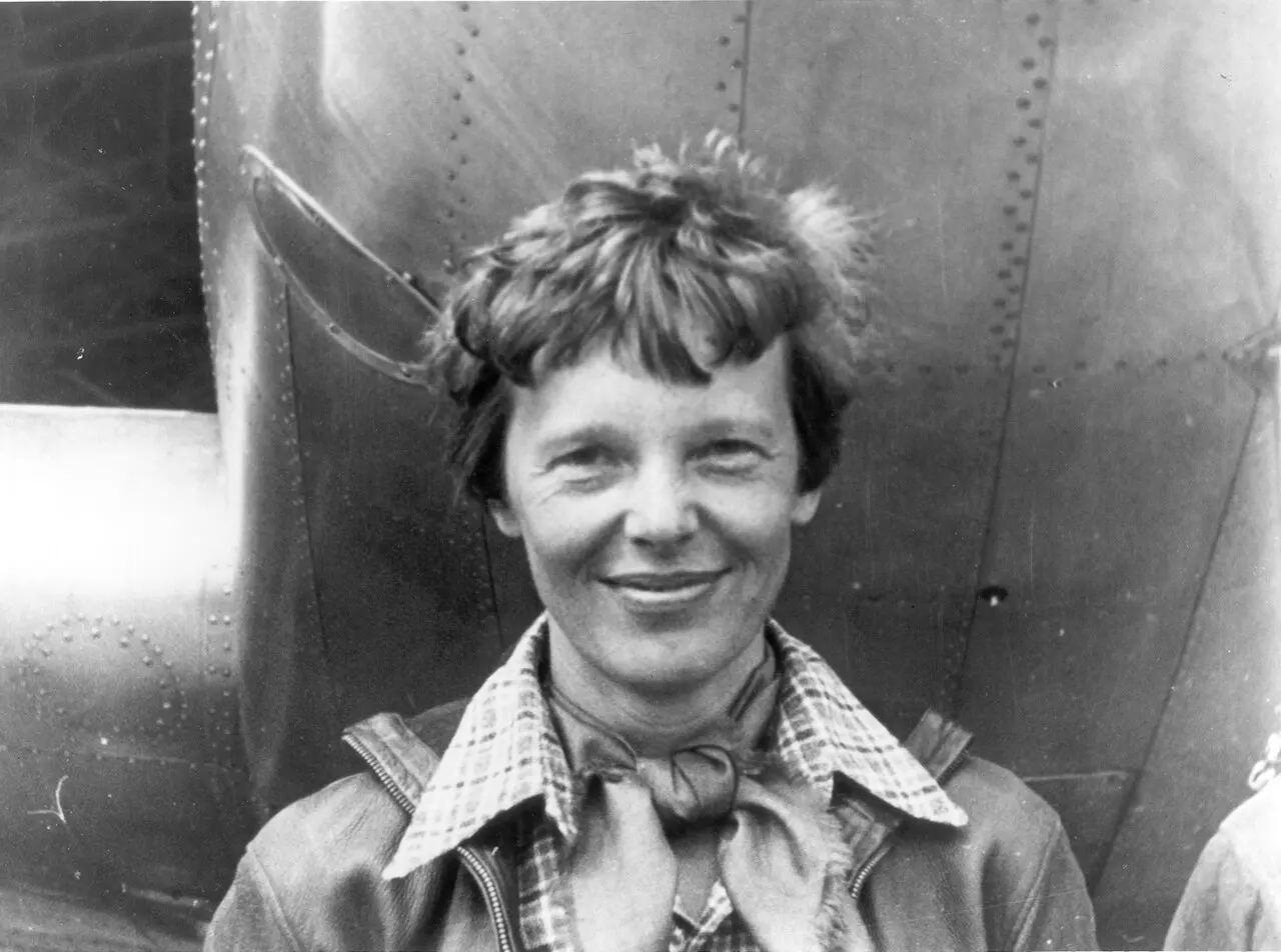 Amelia Earhart standing beneath the nose of her Lockheed Electra in March 1937, months before her disappearance.