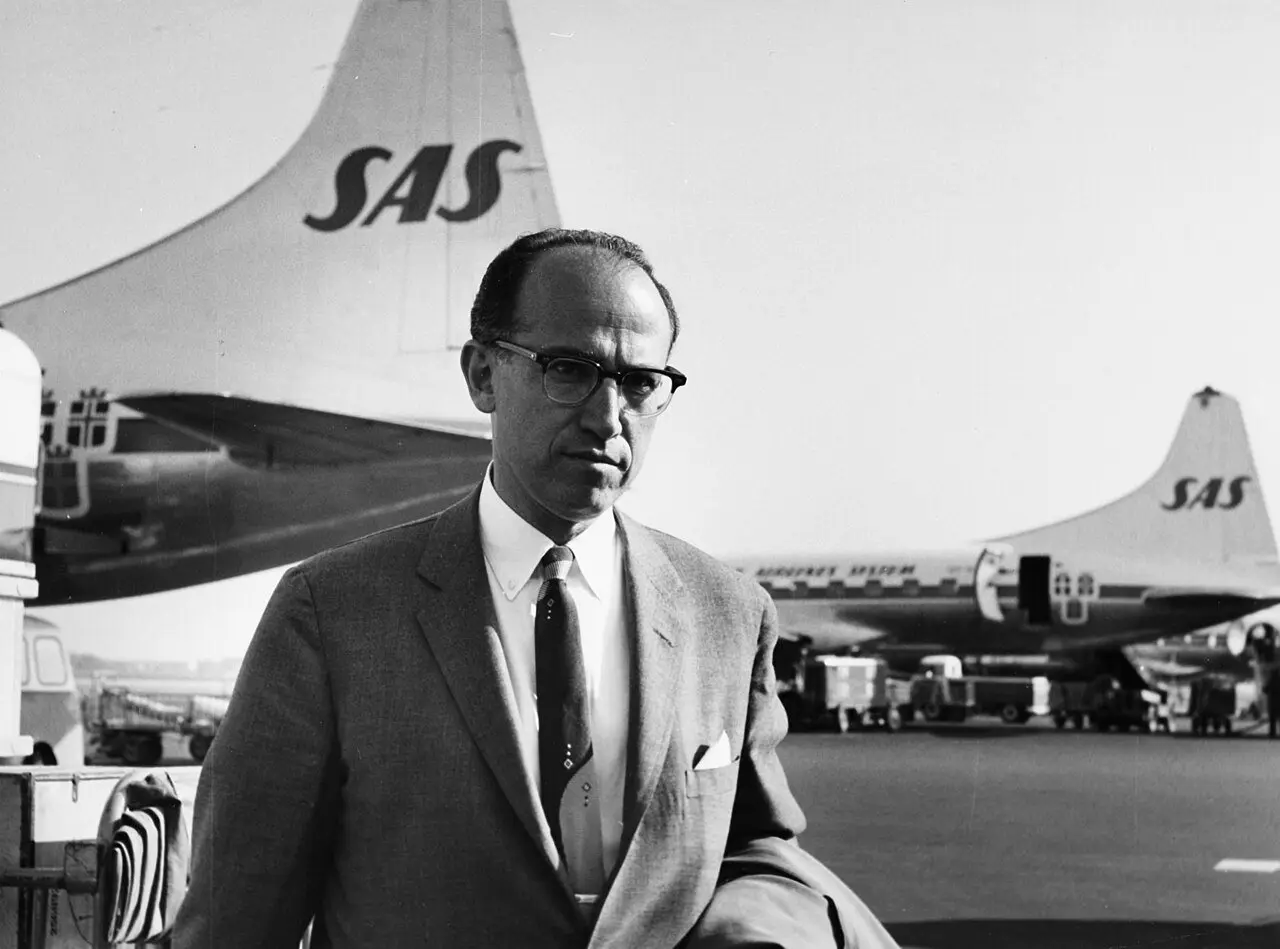 Black-and-white 1959 photograph of Jonas Salk standing in front of a SAS airplane at Copenhagen Airport.