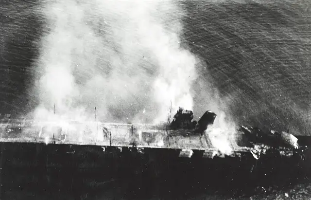 Aerial photograph of the Japanese aircraft carrier Hiryu burning and adrift after U.S. Navy dive-bomber attacks during the Battle of Midway.