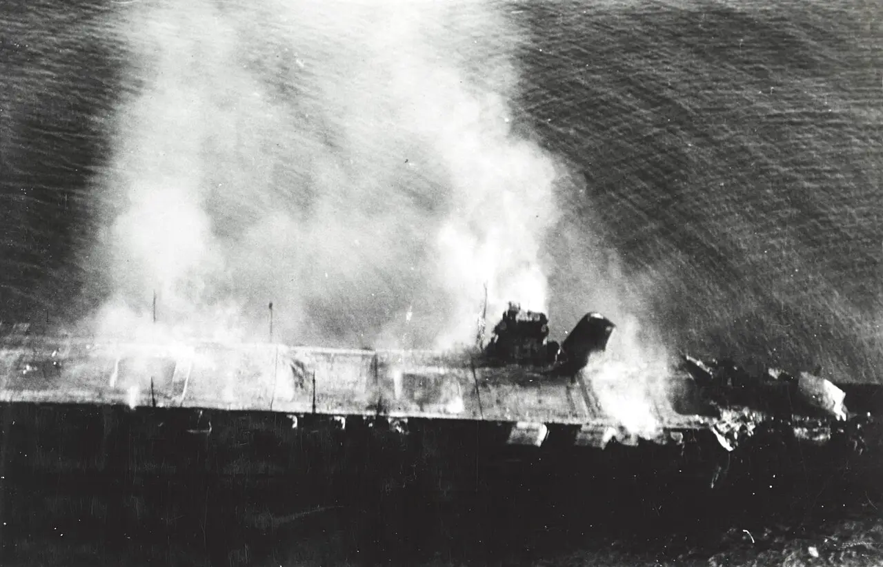 Aerial photograph of the Japanese aircraft carrier Hiryu burning and adrift after U.S. Navy dive-bomber attacks during the Battle of Midway.