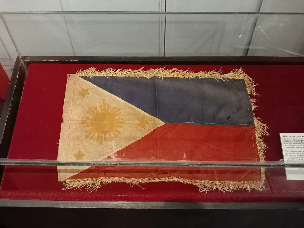 The original Philippine national flag, unfurled during the June 12, 1898 independence proclamation, preserved in a display case at the Aguinaldo Shrine in Kawit, Cavite.