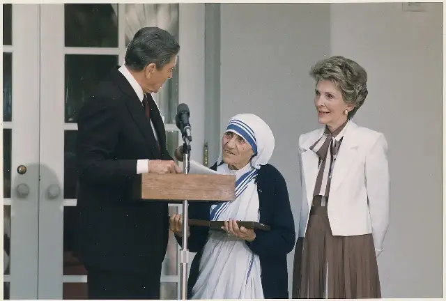 President Ronald Reagan presenting the Presidential Medal of Freedom to Mother Teresa at a White House ceremony, with Nancy Reagan beside them.