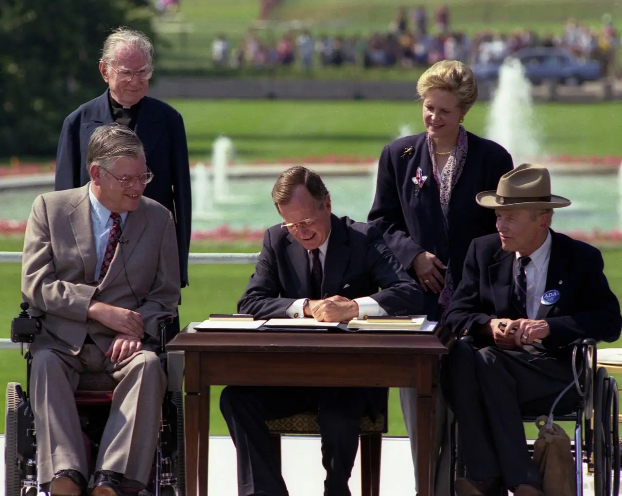 President George H. W. Bush signs the Americans with Disabilities Act on the White House South Lawn, July 26, 1990, flanked by disability advocates.