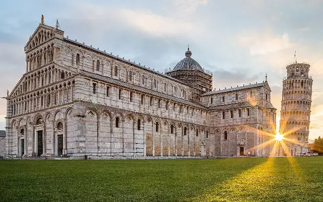 The Leaning Tower of Pisa and the Pisa Cathedral at sunrise in the Piazza dei Miracoli.