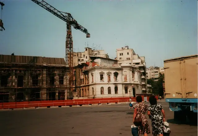 Revolution Square in Bucharest in 1990, with buildings still bearing fire and bullet damage from the December 1989 revolution, under repair