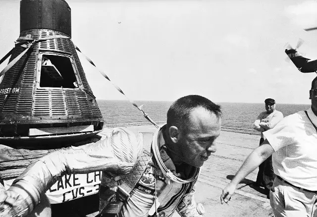 Astronaut Alan Shepard in his spacesuit on the deck of the USS Lake Champlain next to the Freedom 7 capsule, May 5, 1961