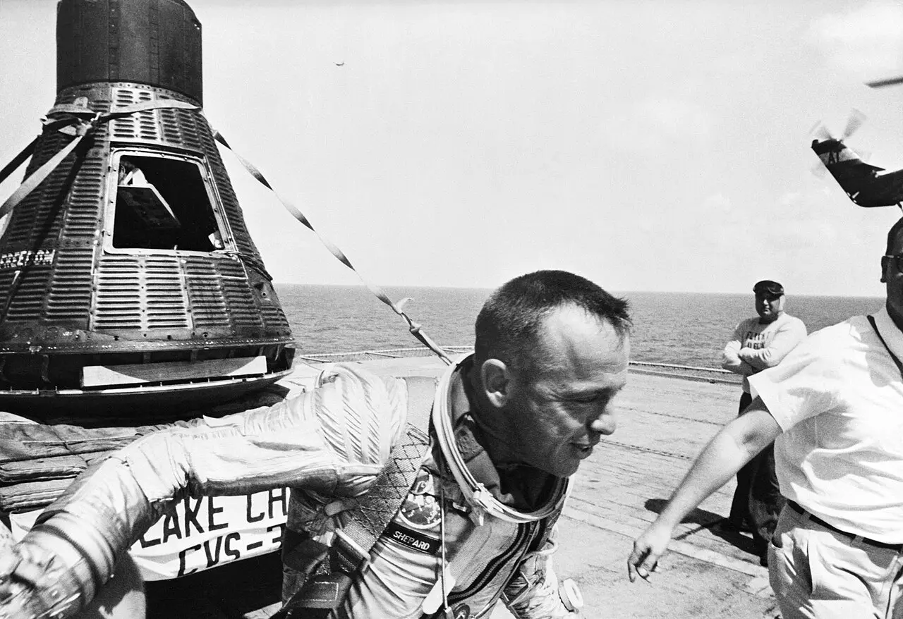 Astronaut Alan Shepard in his spacesuit on the deck of the USS Lake Champlain next to the Freedom 7 capsule, May 5, 1961