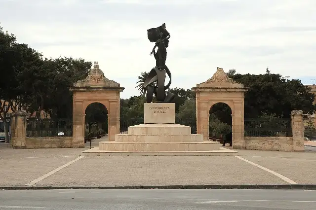 Malta's Independence Monument in Floriana, a bronze figure holding the national flag, inscribed 'INDIPENDENZA 21-IX-1964'