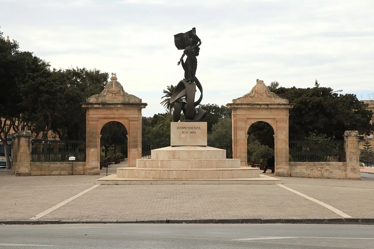 Malta's Independence Monument in Floriana, a bronze figure holding the national flag, inscribed 'INDIPENDENZA 21-IX-1964'