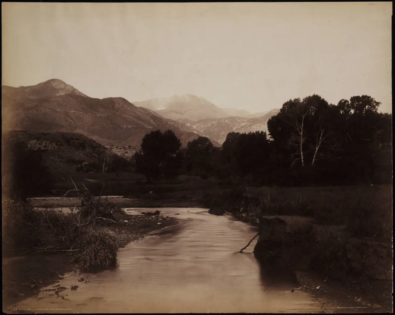 A 19th-century photograph by William Henry Jackson showing Pikes Peak rising in the distance beyond Fountain Creek, Colorado.