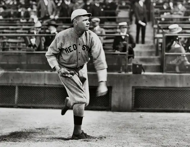 A young Babe Ruth pitching in a Boston Red Sox uniform