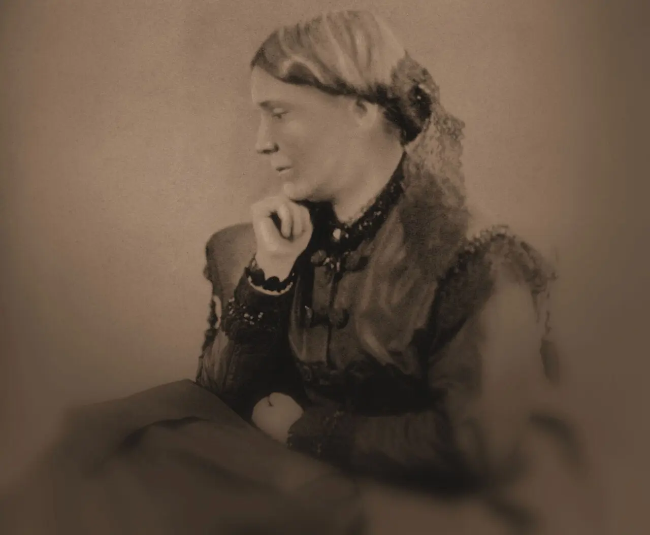 An 1860s-era portrait photograph of Elizabeth Blackwell in profile, chin resting on her hand, wearing a dark Victorian dress.