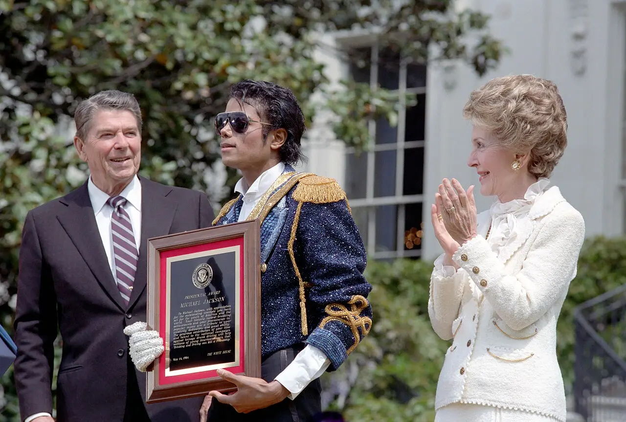 Michael Jackson holding a presidential commendation with Ronald and Nancy Reagan at the White House on May 14, 1984, at the height of Thriller's success (illustrative; the album was released in 1982).