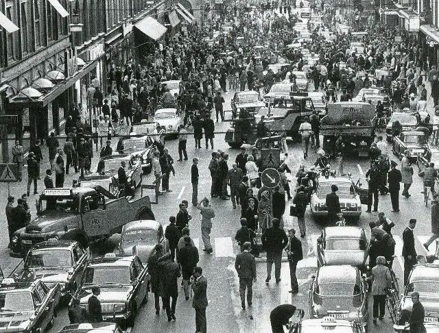 A black-and-white photograph of Kungsgatan in Stockholm on September 3, 1967, with crowds, cars, and police during Sweden's Dagen H traffic switch.