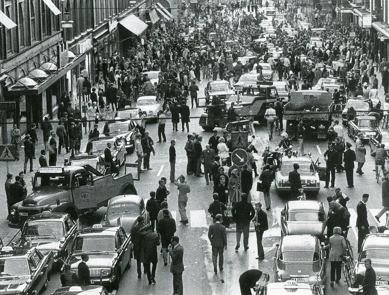 A black-and-white photograph of Kungsgatan in Stockholm on September 3, 1967, with crowds, cars, and police during Sweden's Dagen H traffic switch.