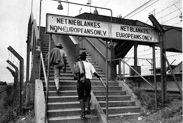 Illustrative: an apartheid-era sign marking separate entrances for 'Europeans' and 'Non-Europeans' at a South African train station.