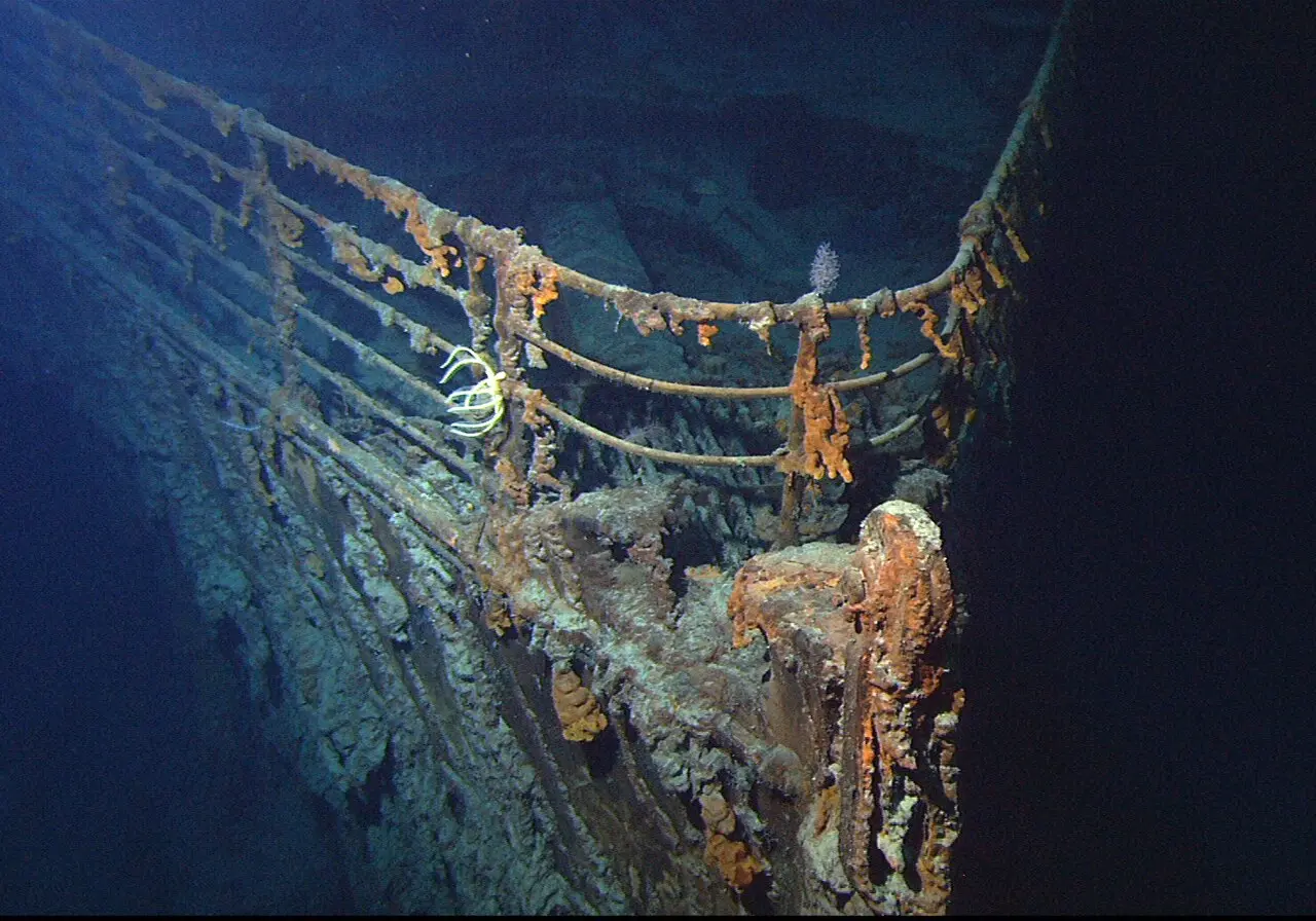 The rusted bow railing of the Titanic wreck, photographed by a remotely operated vehicle in the deep Atlantic.