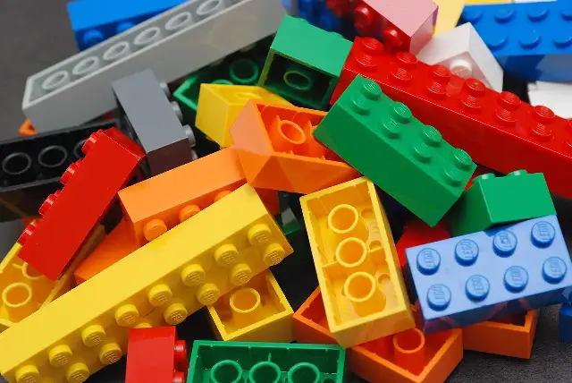 A pile of colorful interlocking LEGO bricks showing their studs and hollow tubes