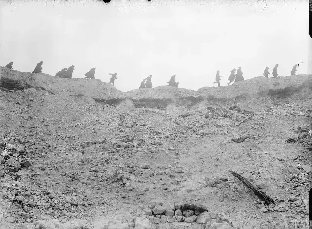 British troops moving along the lip of the Lochnagar mine crater in October 1916, during the Battle of the Somme — an illustration of the devastated battlefield, not the battle's final day.