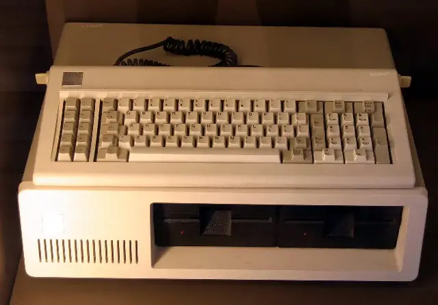 An IBM PC Model 5150 with its keyboard and twin floppy drives, photographed in a museum display