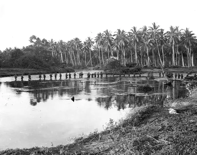 U.S. Marines wading across a river on Guadalcanal, August 1942