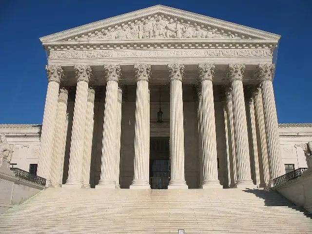 The columned west front of the U.S. Supreme Court building in Washington, D.C., with the words Equal Justice Under Law, beneath a clear blue sky.