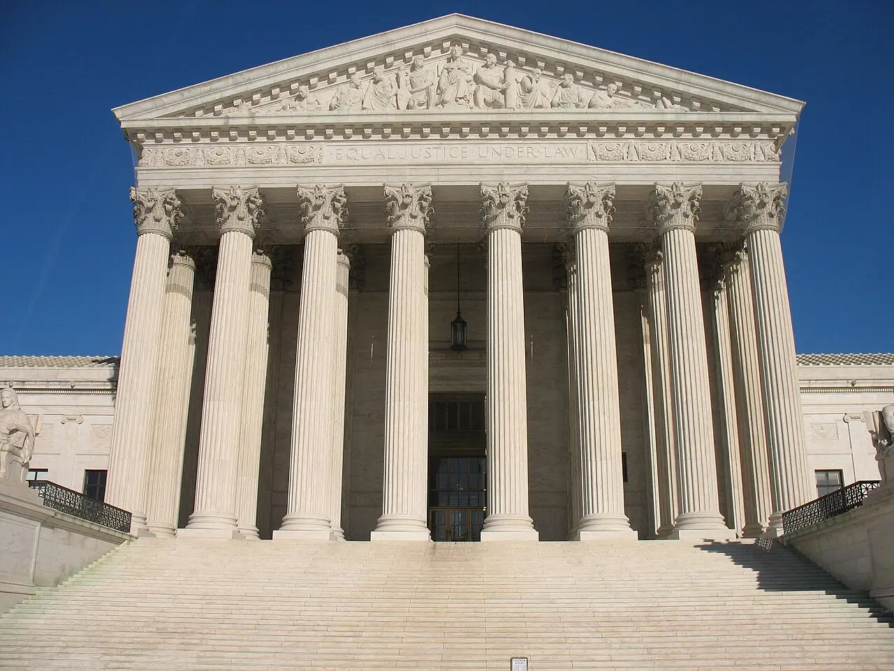 The columned west front of the U.S. Supreme Court building in Washington, D.C., with the words Equal Justice Under Law, beneath a clear blue sky.