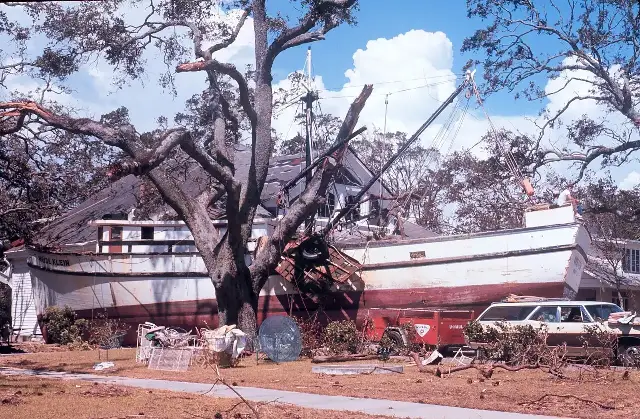 A fishing boat washed up against a house on the Mississippi Gulf Coast after Hurricane Camille, 1969.