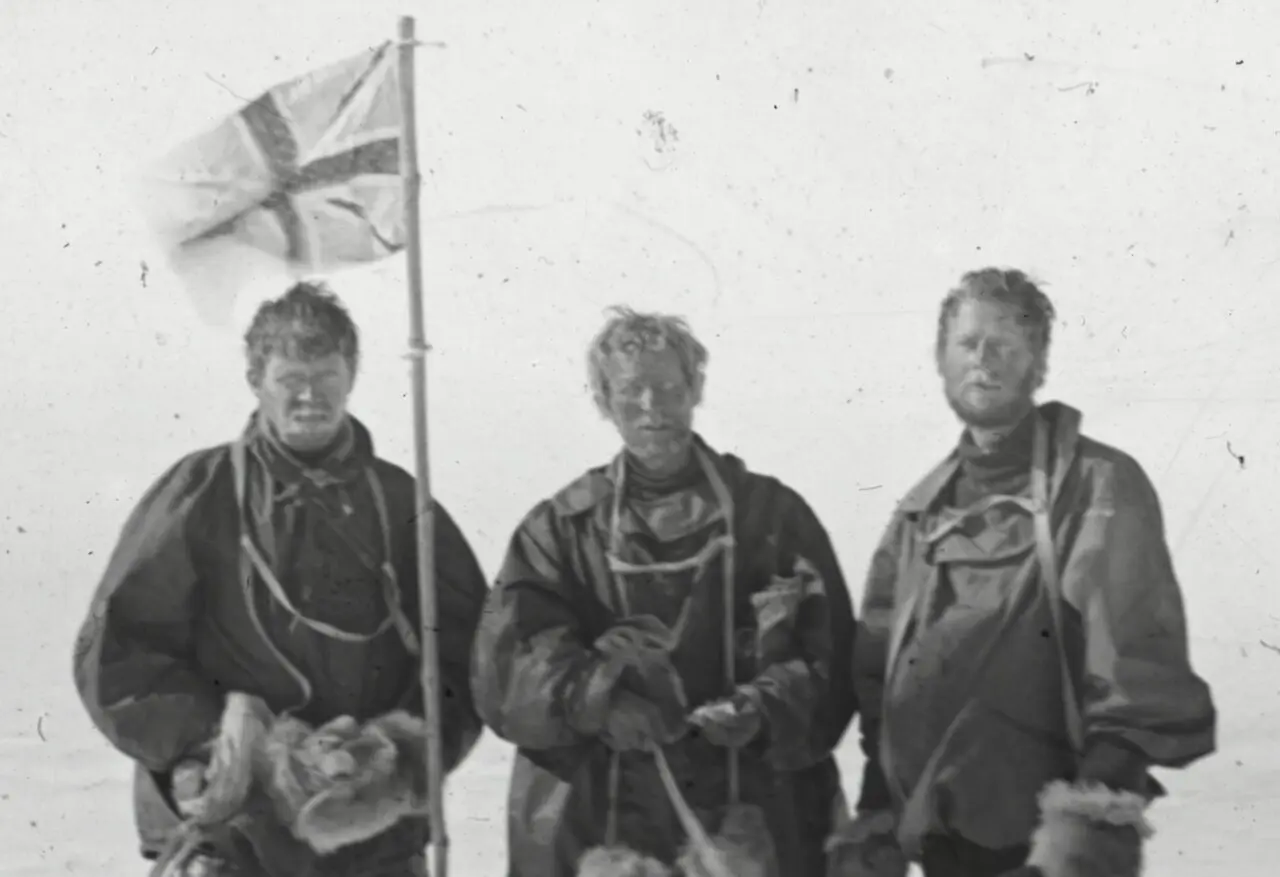 Three exhausted members of Shackleton's Nimrod expedition — Alistair Mackay, Edgeworth David and Douglas Mawson — with the Union Jack at the South Magnetic Pole, January 1909.