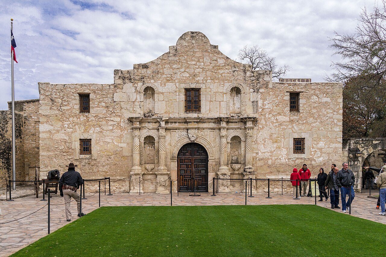 The front of the Alamo chapel in San Antonio, Texas, with visitors on the plaza.