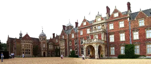 The red-brick entrance front of Sandringham House, Norfolk, on a sunny day