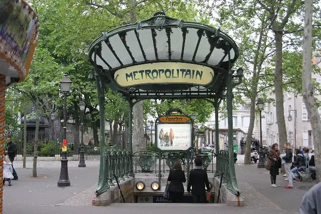 A Hector Guimard Art Nouveau Métro entrance with its glass canopy and METROPOLITAIN sign at Abbesses, Paris