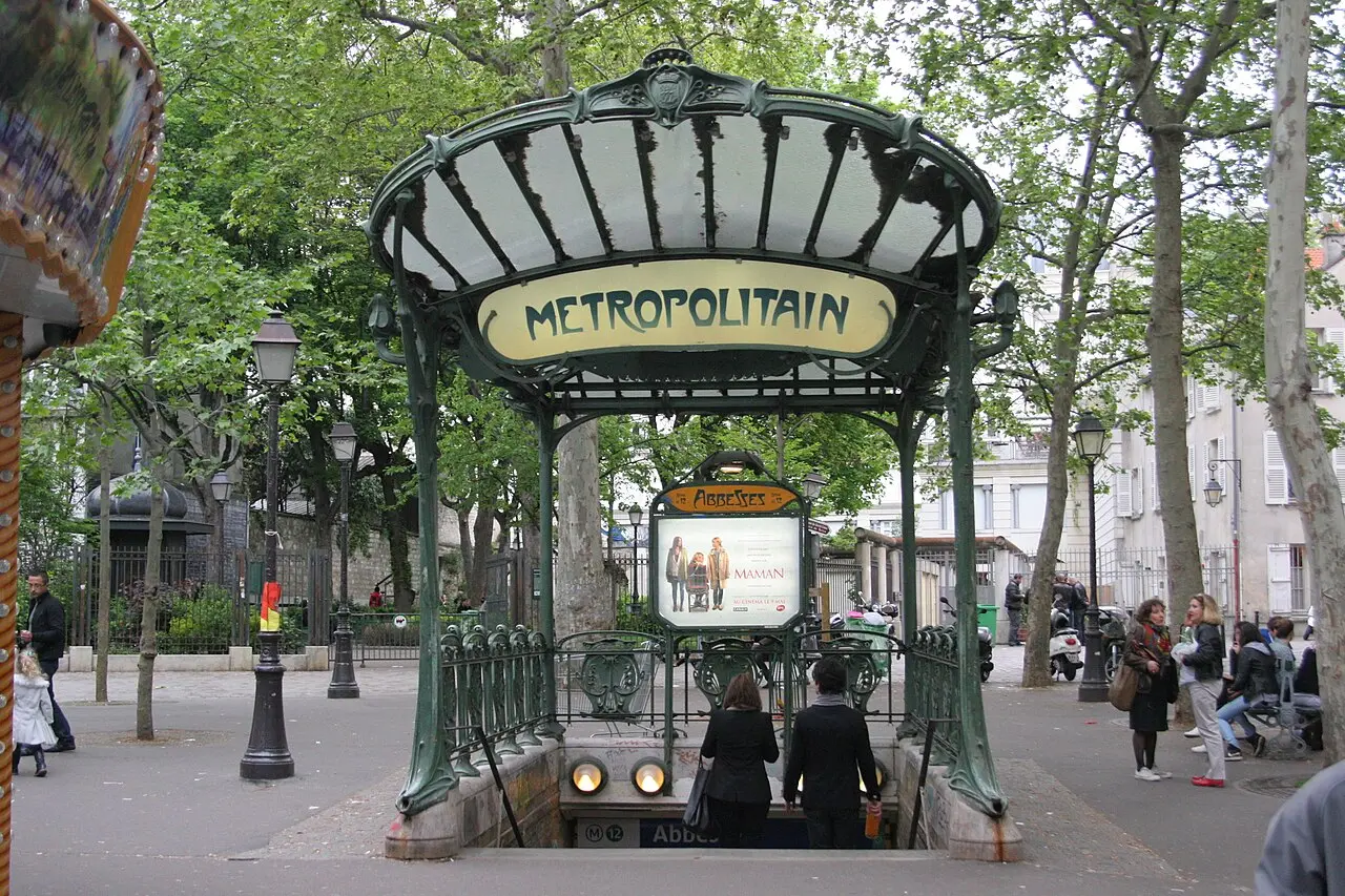 A Hector Guimard Art Nouveau Métro entrance with its glass canopy and METROPOLITAIN sign at Abbesses, Paris