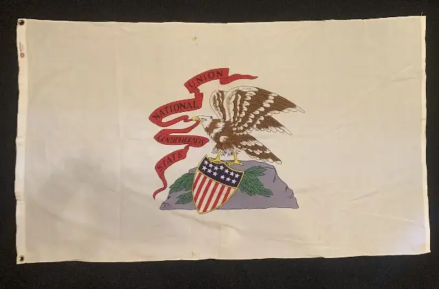A photograph of the Illinois state flag showing its eagle, shield, and State Sovereignty National Union ribbon