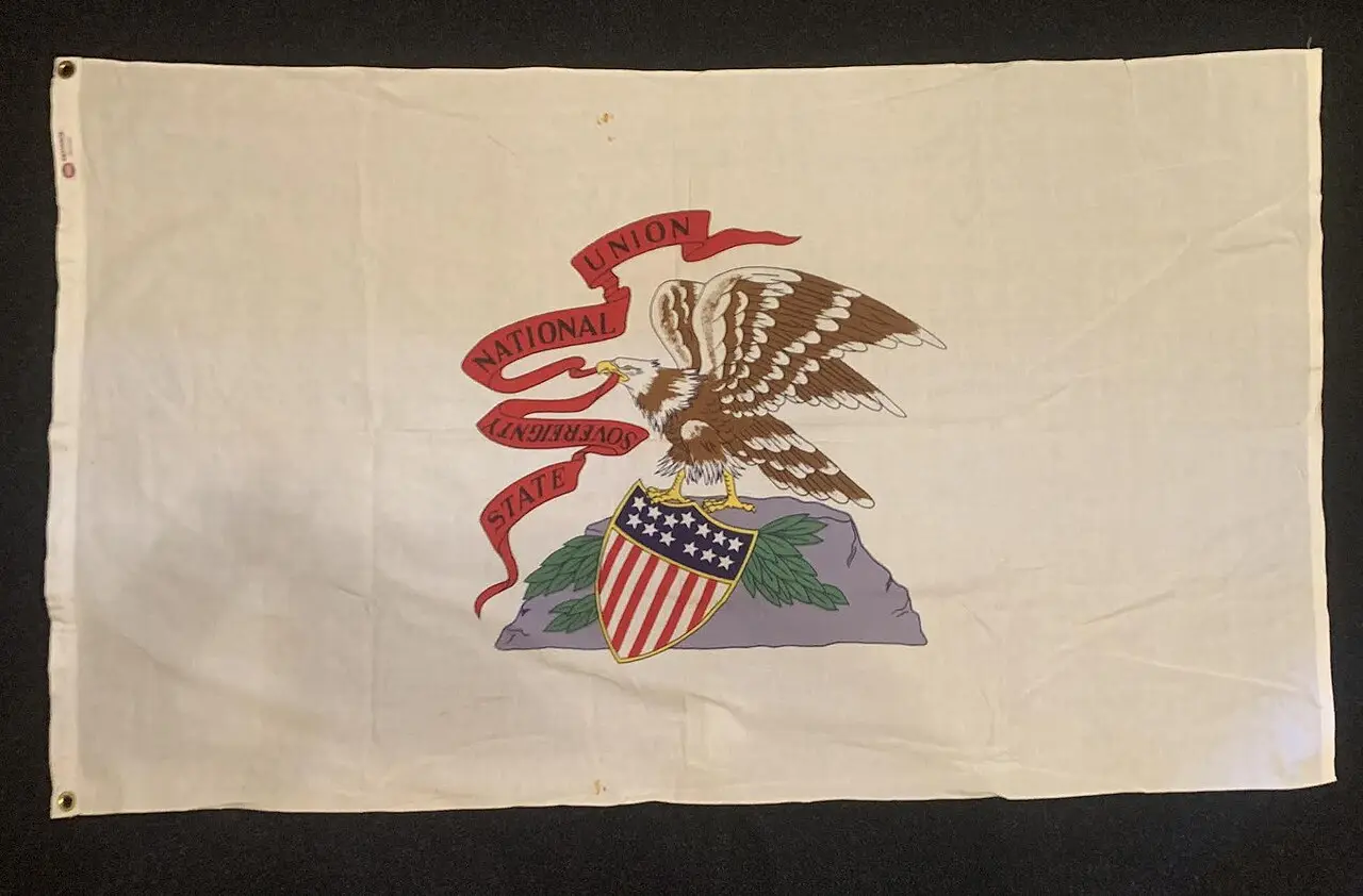 A photograph of the Illinois state flag showing its eagle, shield, and State Sovereignty National Union ribbon