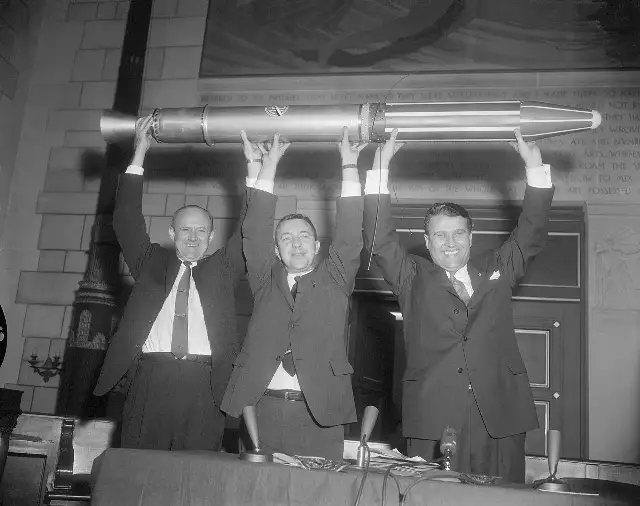 William Pickering, James Van Allen, and Wernher von Braun hoisting a full-size model of Explorer 1 at the 1958 National Academy of Sciences press conference in Washington.