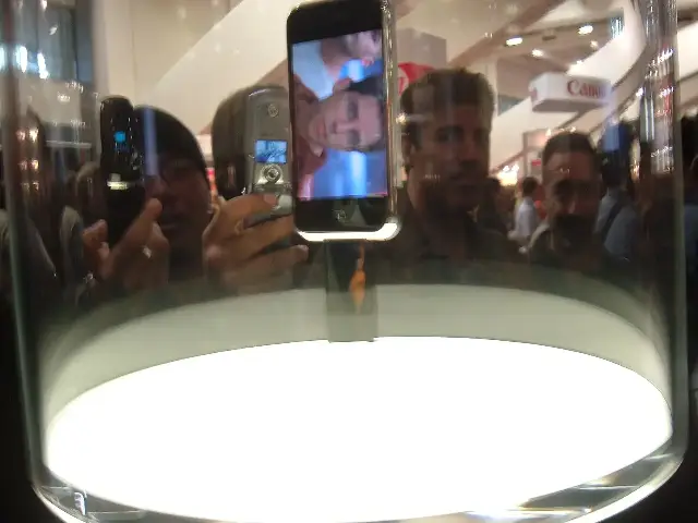 The original first-generation iPhone on display at Macworld 2007, showing its home screen of app icons.