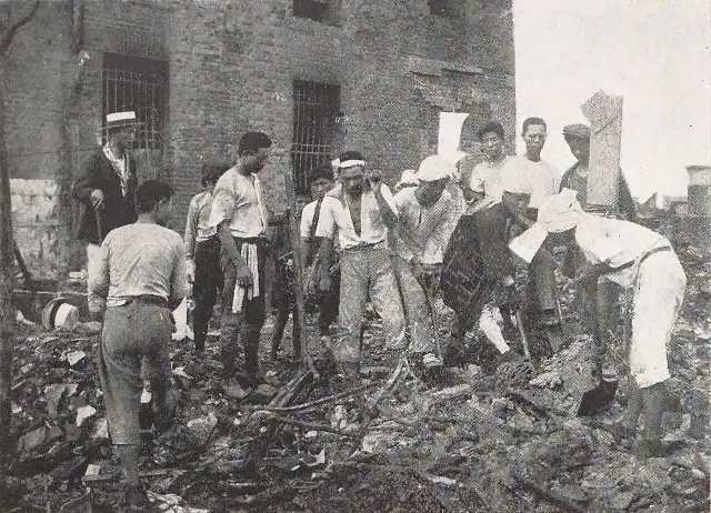 A 1923 photograph of Japanese men clearing rubble from fire-ruined buildings in Tokyo after the Great Kantō earthquake.