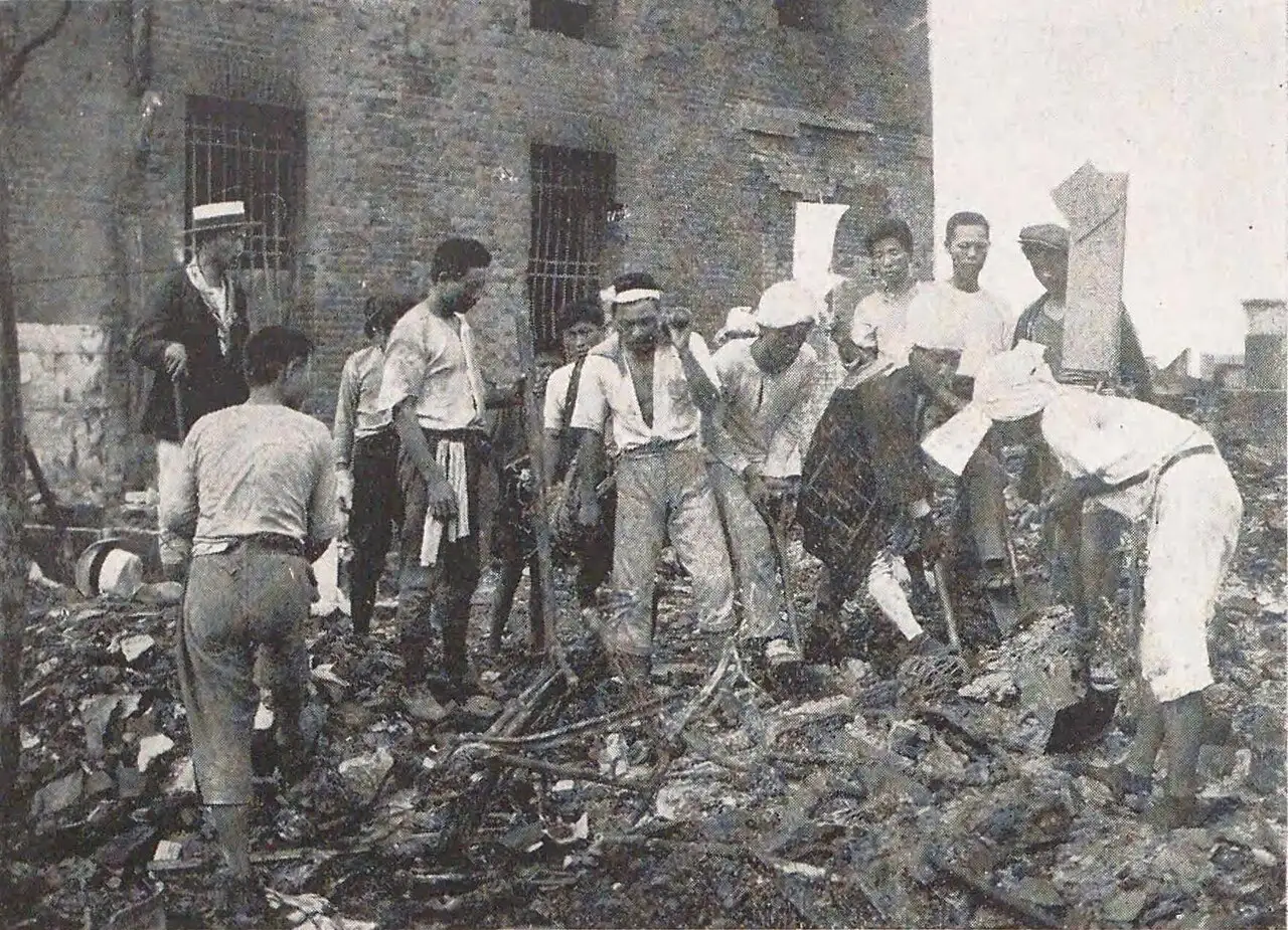 A 1923 photograph of Japanese men clearing rubble from fire-ruined buildings in Tokyo after the Great Kantō earthquake.