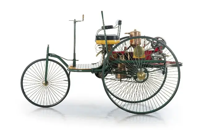The Benz Patent-Motorwagen, Karl Benz's three-wheeled automobile with wire-spoked wheels, shown in a studio photograph.