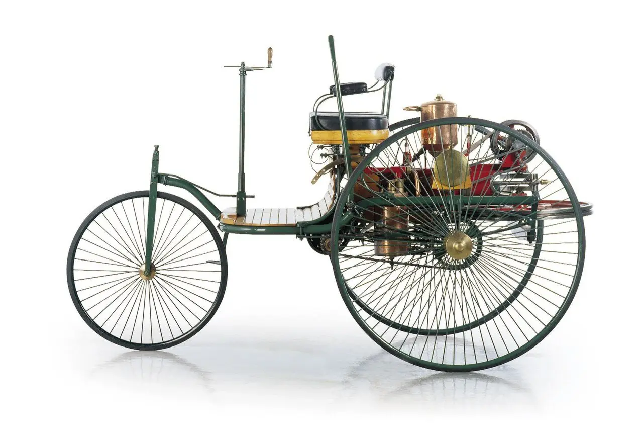 The Benz Patent-Motorwagen, Karl Benz's three-wheeled automobile with wire-spoked wheels, shown in a studio photograph.