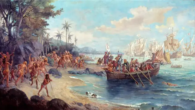 Oscar Pereira da Silva's 1902 painting of Pedro Álvares Cabral's landing at Porto Seguro: Portuguese caravels anchored offshore, a longboat of armored soldiers reaching the beach, and Indigenous people watching from the sand.