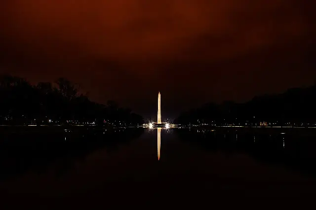 The Washington Monument illuminated at night, reflected in the Lincoln Memorial Reflecting Pool