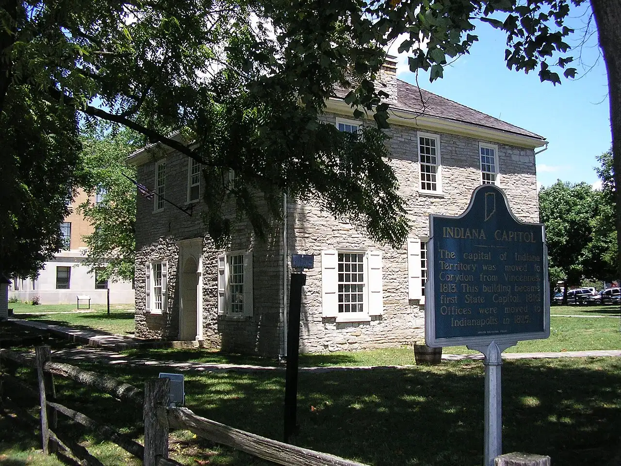 The old Indiana state capitol building in Corydon, a two-story stone building with a historic marker in front.